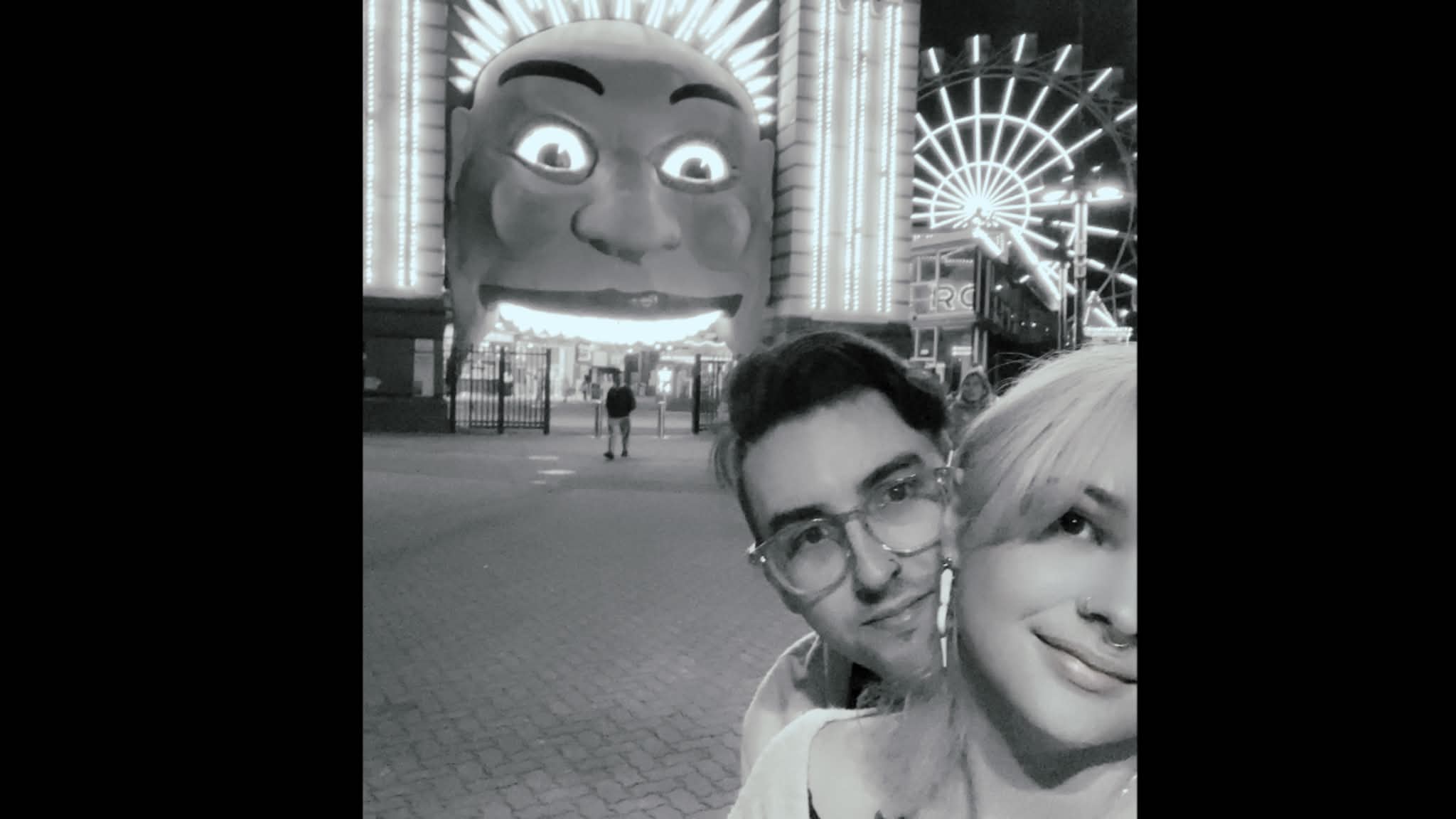 A black-and-white night shot at an amusement park