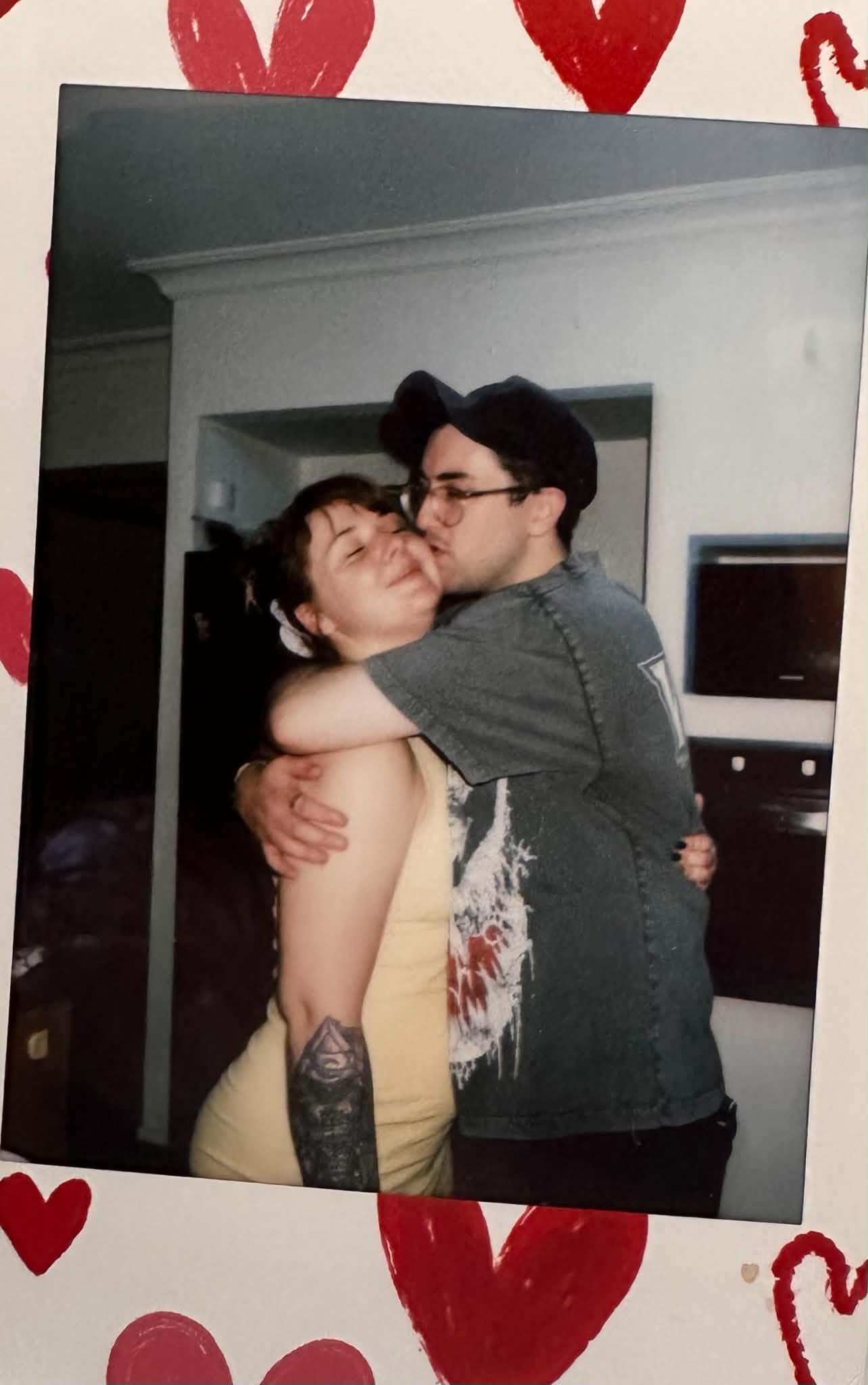 A vintage-style photo of the two of them hugging, framed by hand-drawn hearts